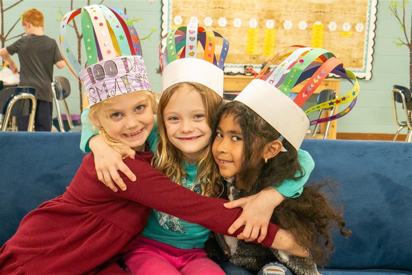 three girls smiling in 100 days smarter hats